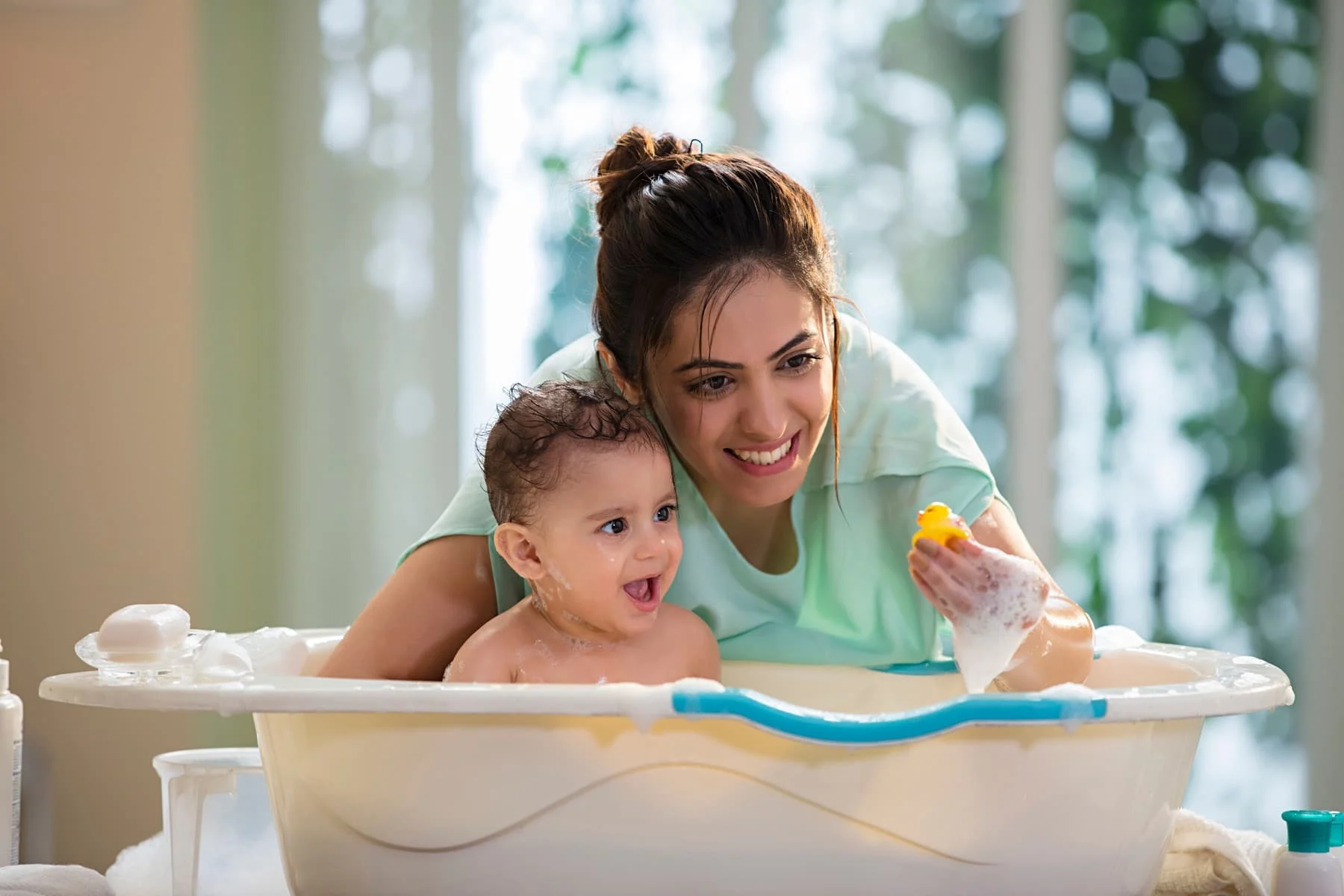 Mother bathing a happy baby