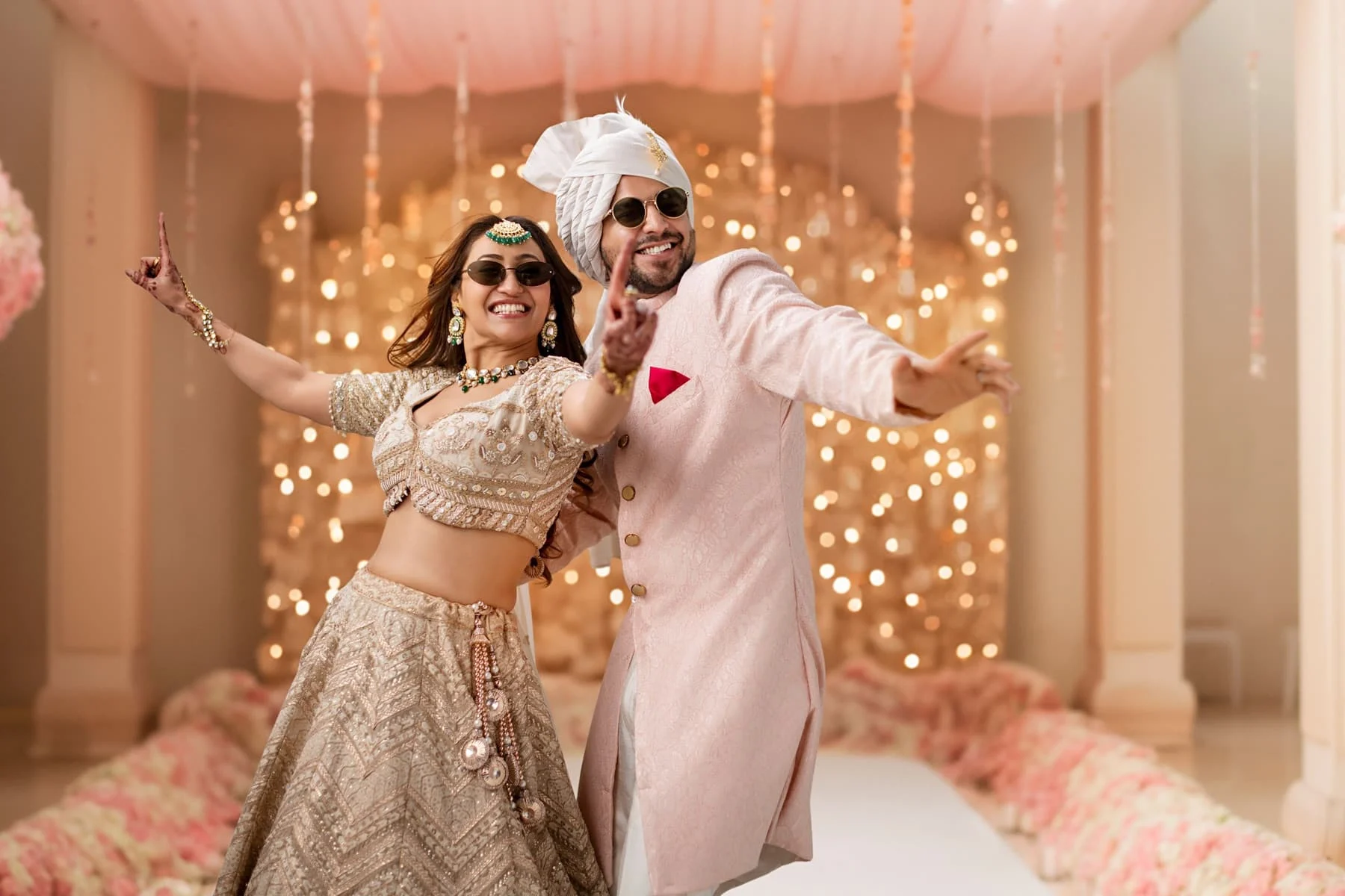 Couple posing playfully in front of fairy lights at a pre-wedding shoot
